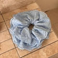 Detalle de coletero de encaje azul claro con bordado calado y bordes ondulados - Azul