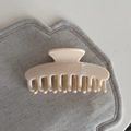 Macro shot of minimalist cream-colored resin shark hair claw clip with a polished finish - Small Bone Style