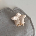 Detail view of cream floral hair claw clip with geometric textured petals and sleek teeth - Single Flower Style
