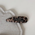 Close-up of leopard print fabric hair clip on soft beige linen cushion background - Leopard Teardrop BB Clip