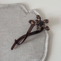 Vue détaillée d'une pince à cheveux à fleur léopard sur un fond en tissu de lin neutre - Pince Banane Fleur / Léopard Brun