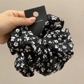 Détail du chouchou en satin à fleurs gris-rose avec texture soie et motif de trèfles - Chouchou / Noir Imprimé