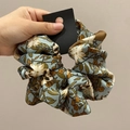 Detail of grey-pink floral and leopard print satin scrunchie with silky texture - Approx. 18cm Diameter / Green Floral