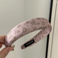 Détail d'un serre-tête en satin rose à fleurs avec étiquette de fabrication artisanale - Serre-tête Rembourré / Imprimé Rose
