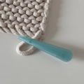 Gros plan détaillé d'une pince à cheveux en acétate turquoise faite main sur du tricot - Vert