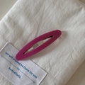 Detailed close-up of a French vintage oval hollow hair clip in magenta acetate finish - Pink