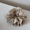 Primer plano de coletero de tela beige con borde volante en escritorio blanco minimal - Beige