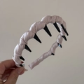 Detalle de diadema de satén beige con dientes de peine negros para sujeción firme - Rosa
