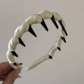 Detail of beige satin padded headband featuring integrated black plastic wavy hair comb teeth - Green