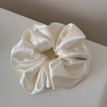 Detail view of cream satin scrunchie with subtle silver sparkles and high-end texture - Shimmer Scrunchie / Off-white