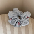 Dettaglio dell'elastico a righe blu con fiocchi rossi ricamati e trama del tessuto - Righe Blu - Fiocco