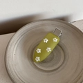 Detail of green floral acrylic hair clip with white 3D flowers in a ceramic bowl - Green