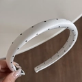Detail of white satin headband with black polka dots featuring thick padded design and inner teeth - Narrow Headband / White