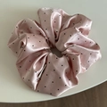 Close-up of pink satin scrunchie with black polka dots and silky pleated texture - Scrunchie / Pink