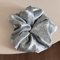 Macro detail of a satin light blue scrunchie with black polka dots and soft texture - Scrunchie / Blue
