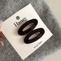 Detail view of dark brown oval acetate hair clips with metallic spring on brand card - Dark Coffee