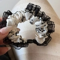 Dettaglio dell'elastico per capelli con stampa floreale nera, pizzo e perla decorativa - Stile Pieghettato Floreale Nero - Semplice