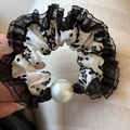 Dettaglio di scrunchie a pois bianchi e neri con bordo in pizzo e grande perla - Stile Pieghettato Floreale Nero - Decorazione Perle