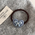 Vue détaillée d'un élastique à cheveux cœur avec strass et motif nœud sur tissu tricot - Bleu