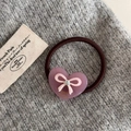 Dettaglio di un elastico per capelli marrone con cuore in acrilico viola e fiocco rosa - Rosa