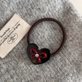 Dettaglio di elastico per capelli a cuore con fiocco rosso e cristallo su tessuto - Nero