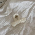 Detail of cream white acetate bow hair clip with textured pearl finish and metal spring - White Claw Clip - Bow