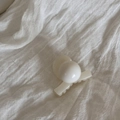 Detailed top view of a minimalist cream white pearl hair claw clip on white fabric - White Claw Clip - Cross with Bead