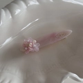 Detailed macro view of pink resin flower hair clip with pearls and marble texture - Pink