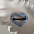 Detail of heart-shaped blue denim fabric hair clip with stitching on beige ceramic plate - Light Blue Denim-Heart