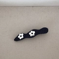 Detail of black denim bow hair clip with silver metallic flower and heart-shaped hollows - Wave Flat Clip (FJ89976)