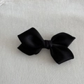 Detailed macro shot of the black satin fabric texture on a ribbon hair clip - Black