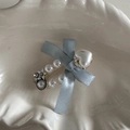 Close-up of pearl hair clip with blue bow, silver stars and heart on ceramic plate - Light Blue Heart Pearl Oval