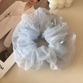 Close-up of light blue mesh scrunchie with tiny white bows for ballet style hair - Blue