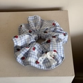 Close-up of blue plaid scrunchie with strawberry embroidery and white lace bow detail - Blue Gingham Strawberry Scrunchie