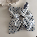 Gros plan du chouchou à pois bleus avec coutures détaillées sur une surface blanche - Pois Bleus Anneau Carré