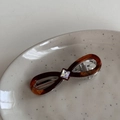 Dettaglio di un fermaglio per capelli tartarugato con segno infinito e strass quadrato - Tartaruga Scura