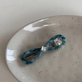 Detail of blue-green marble acetate hair clip with a square crystal and silver spring clip - Blue