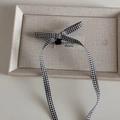 Detail of checkered bow hair clip with long ribbons on a minimalist display box - Black White Small Grid