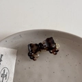 Détail d'une mini pince à cheveux en acétate avec motif tortue posée sur une assiette - Écaille de Tortue