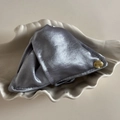 Nahaufnahme einer silbernen Satin-Haarklammer mit goldener Gravur-Plakette Believe In Yourself - Blau