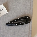 Nahaufnahme der klassischen schwarzen Tropfen-Haarklammer mit weißen Punkten auf Stoff - Schwarz Wassertropfen Polka Dot Leder