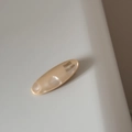 Detail of acetate oval hair clip with champagne pearl texture and handmade text - Cream
