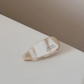 Gros plan sur la barrette goutte en acétate marbré avec lettrage Barrette La France - Blanc Lait