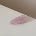 Détail macro d'une barrette à cheveux rose en acétate avec texture marbrée et gravure dorée - Rose Violet