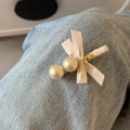 Dettaglio elegante fermaglio per capelli con perle e fiocco su sfondo di jeans blu - Bianco