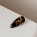 Gros plan sur la pince à cheveux en acétate écaille avec gravure Barrette France précise - Écaille de Tortue