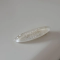 Primer plano de un clip para el pelo ovalado con purpurina y escamas plateadas en resina - Blanco