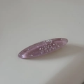 Macro detail of oval resin hair clip with glitter and shimmering seashell fragments - Purple