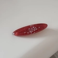 Detailed close-up of a red oval resin hair clip with fine glitter and shimmer flakes - Red