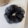Detailed macro of black sequin organza scrunchie with shimmering glitter decorative trim - Black